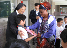 小朋友感謝遠道來訪的剛果共合國Pascaline Bimpe小姐，特別與校長施麗蘭修女一起贈送小禮物給遠道來訪的客人。